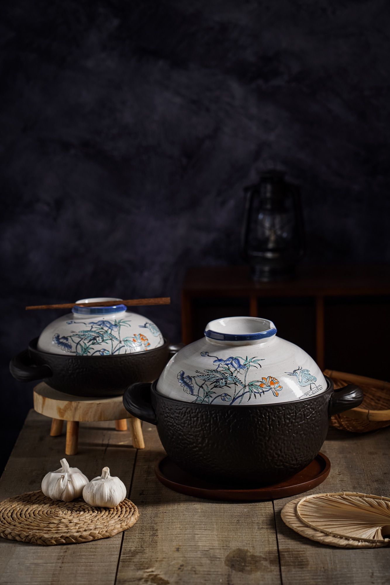 Glazed ceramic casserole with its patterned lid on a dark textured background.