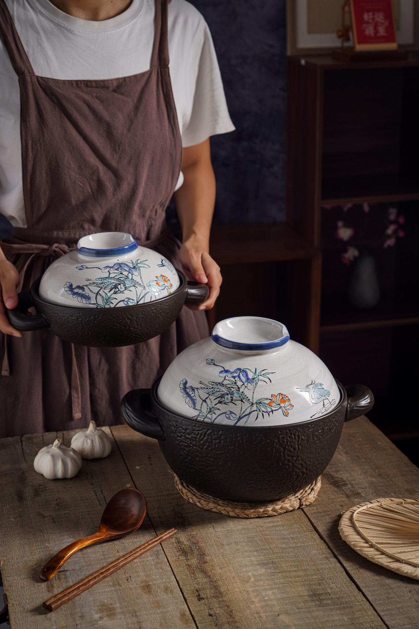 A person holding a glazed ceramic casserole by its side handle.