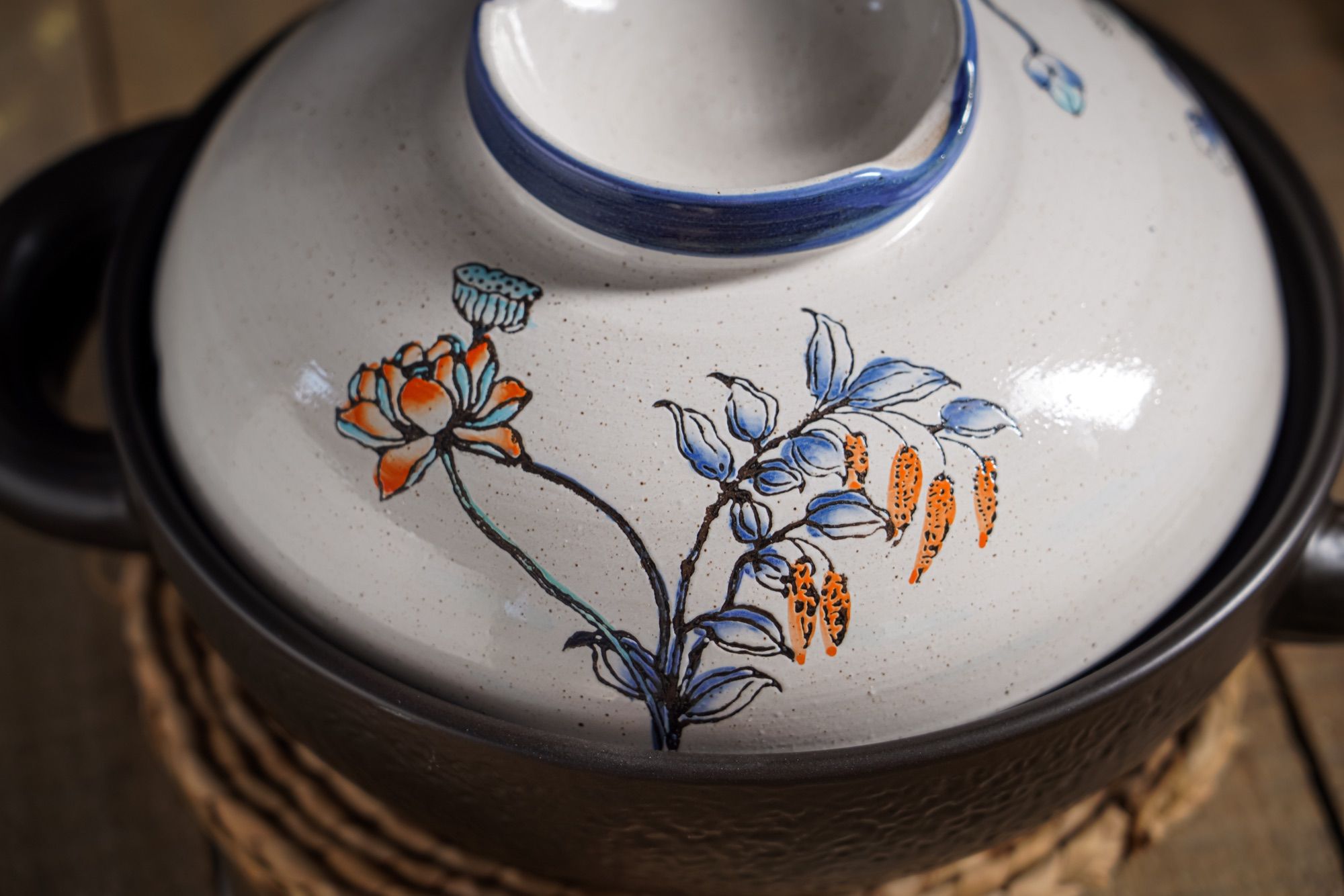 Close-up of a patterned ceramic lid with a blue rim.